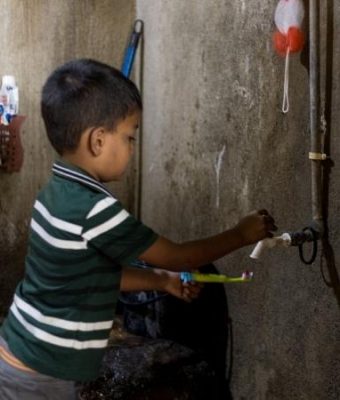 Rakshan uit Sri Lanka spoelt zijn tandenborstel af onder de kraan.