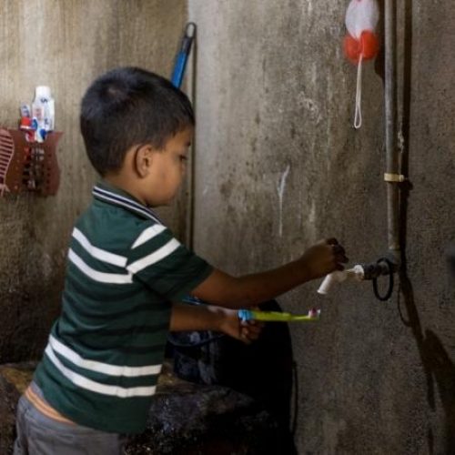 Rakshan uit Sri Lanka spoelt zijn tandenborstel af onder de kraan.