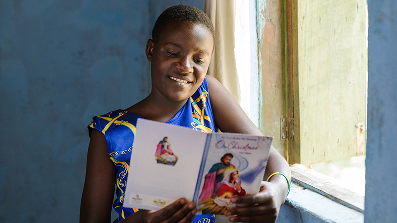 Brenda uit Uganda leest haar kerstkaart.
