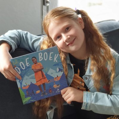 Charlie houdt het doeboekje van Compassion vast.