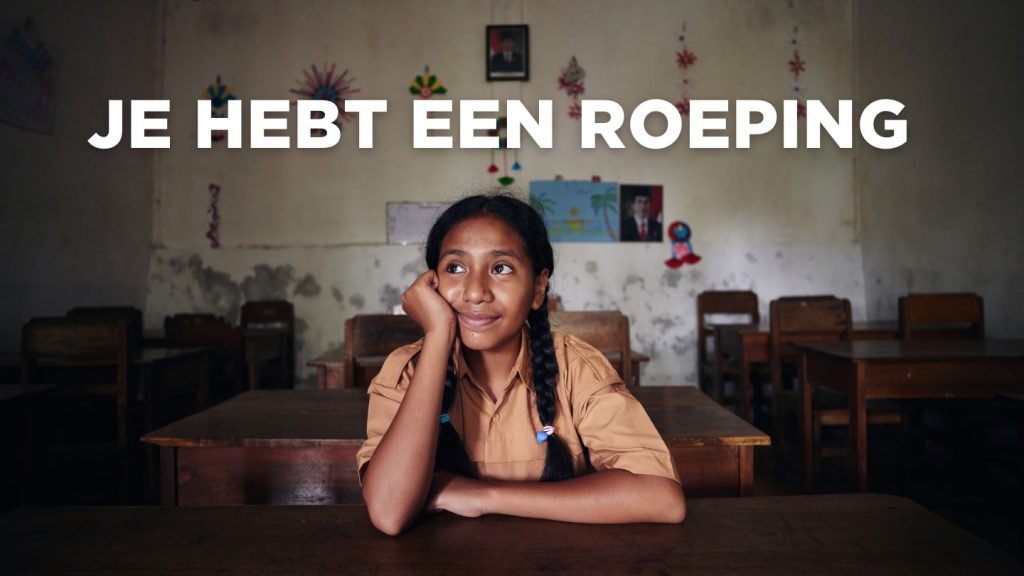 Een meisje zit in een schoolbank.