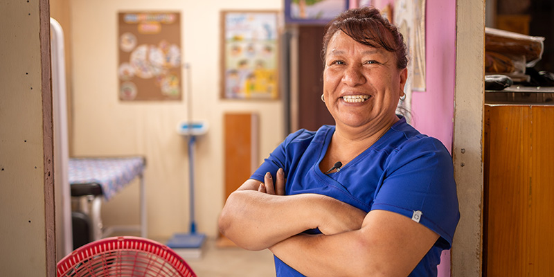 Gezondheidsspecialist Angela uit Peru staat met haar handen over elkaar op een Compassion-project.