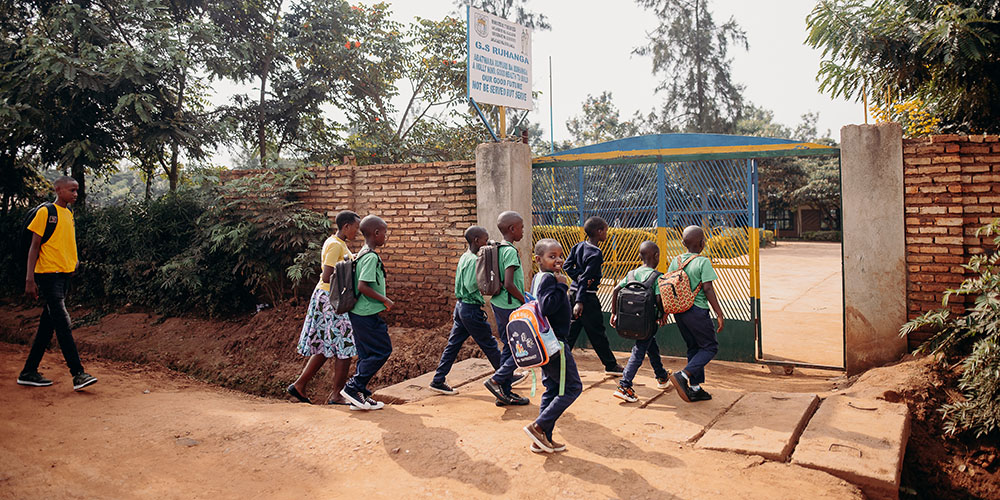 Kinderen lopen het terrein van een Compassion-project in Rwanda op.