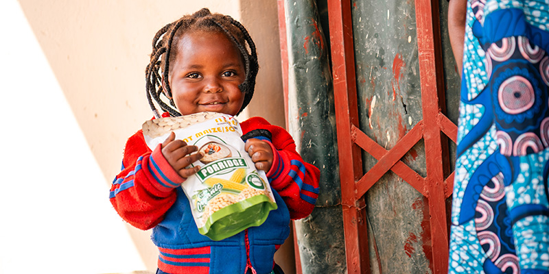 Sarah uit Zambia houdt een pak pap vast.