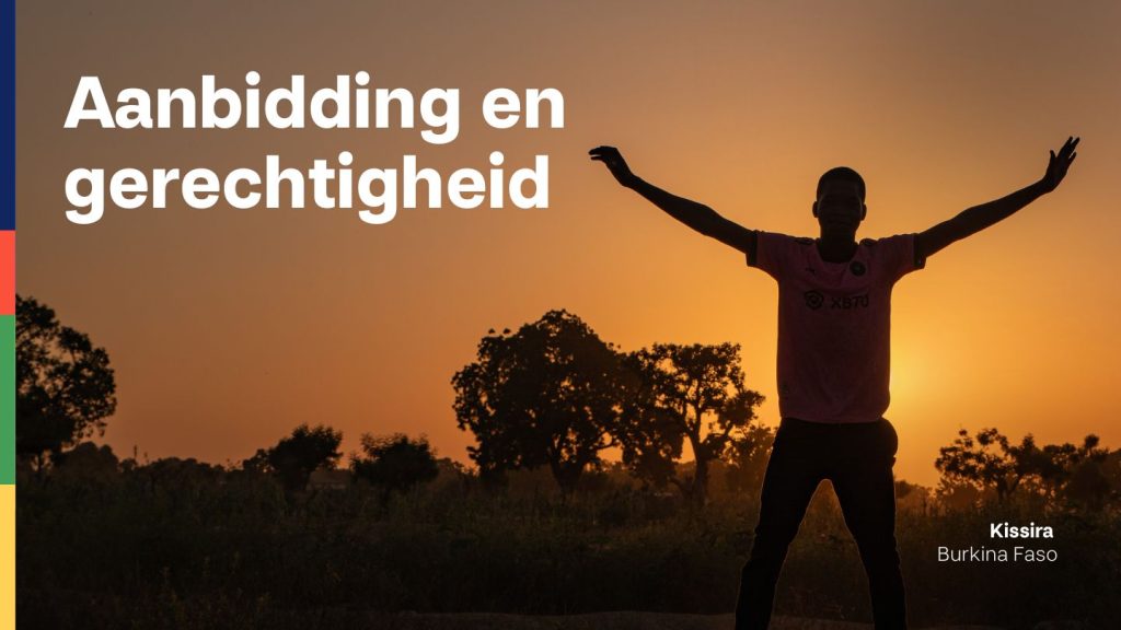 Kissira uit Burkina Faso staat bij zonsondergang met zijn armen wijd in het veld.