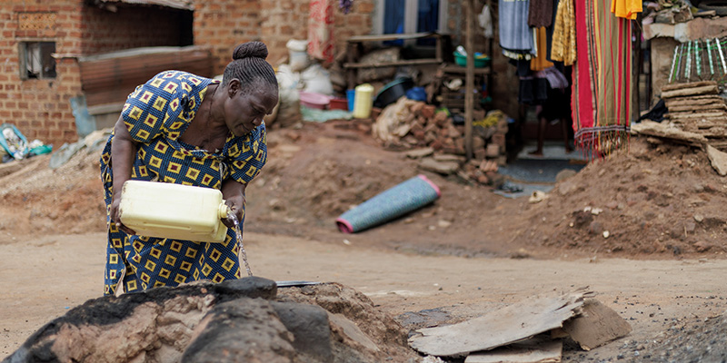 Oma Prossy uit Uganda giet water uit een jerrycan.