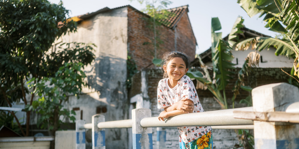 Talitha uit Indonesië staat in de achtertuin van haar huis.