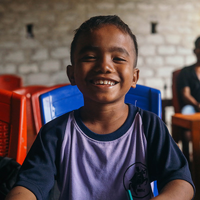 Jendri uit Indonesië kijkt lachend in de camera.