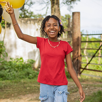 Kelen uit Colombia lacht met ballonnen in haar hand. 