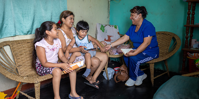 Projectmedewerker Angela uit Peru is op bezoek bij een moeder met twee kinderen.
