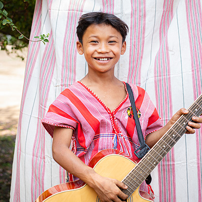 Say Wah uit Thailand houdt een gitaar vast.
