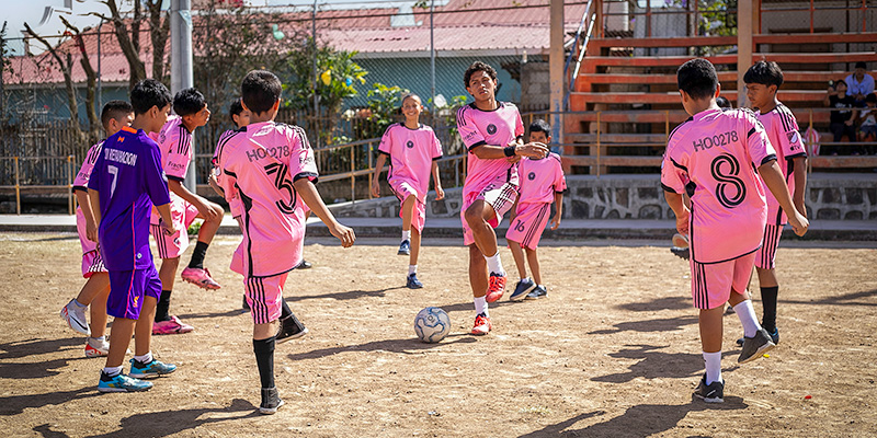 Alejandro uit Honduras geeft voetbaltraining aan een groep jongens.