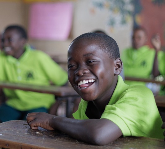 Jordan lacht tijdens een les op het Compassion project.