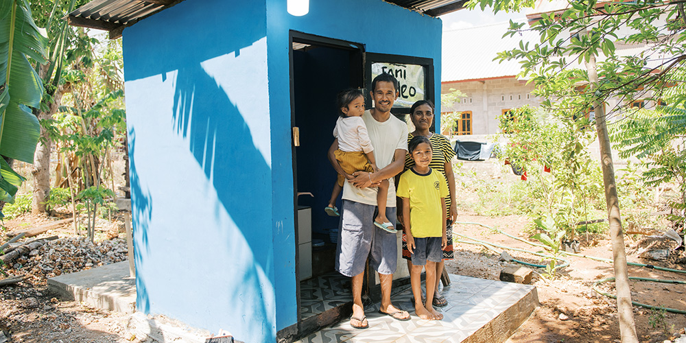 Nyongki uit Indonesië staat samen met zijn gezin voor hun nieuwe toilet.