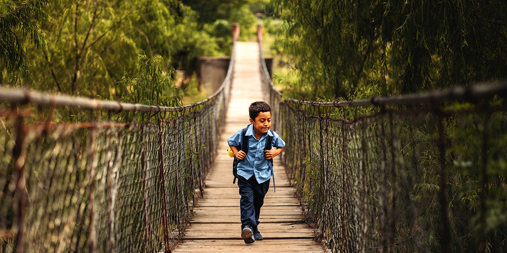 Anderson uit Guatemala loopt over een hangbrug.